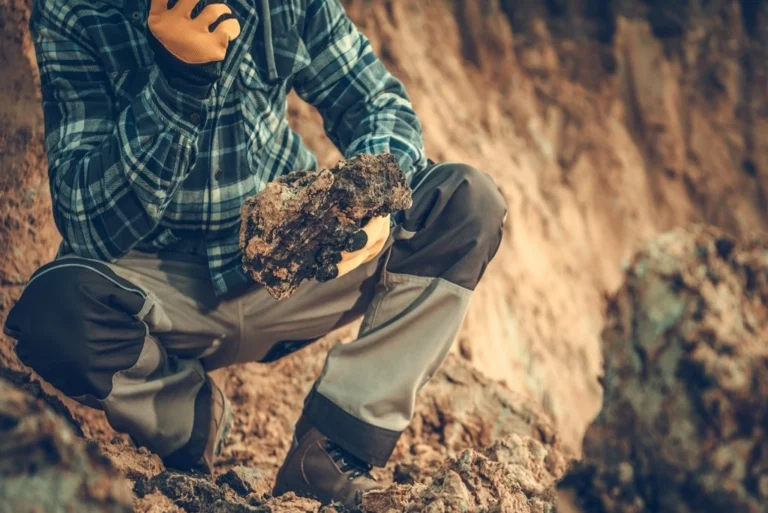 Joven profesional analizando datos en un campo solar, representando las diversas carreras medio ambiente y oportunidades laborales en sostenibilidad