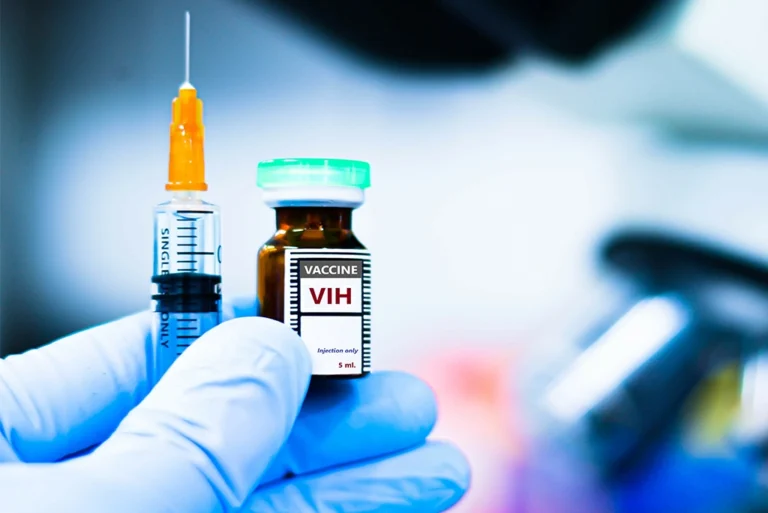 Primer plano de una mano con guante sosteniendo una jeringa y un frasco etiquetado como vacuna contra el VIH, destacando avances en la inyección para prevenir el VIH.