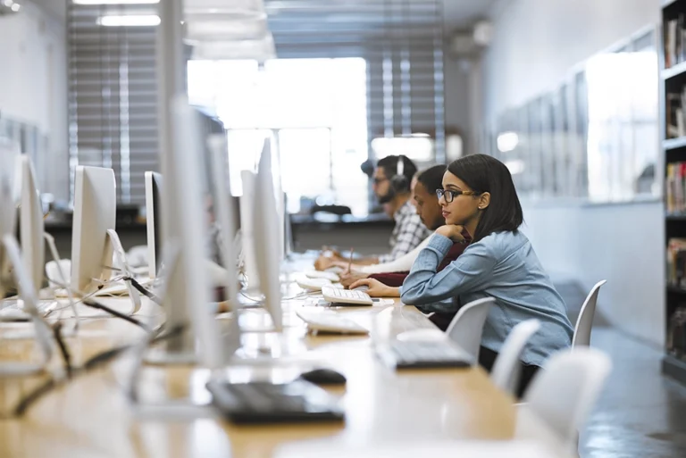 Un grupo de estudiantes universitarios sonrientes y motivados interactuando en un aula moderna, simbolizando el aprendizaje dinámico y las oportunidades que ofrecen los cursos intersemestrales