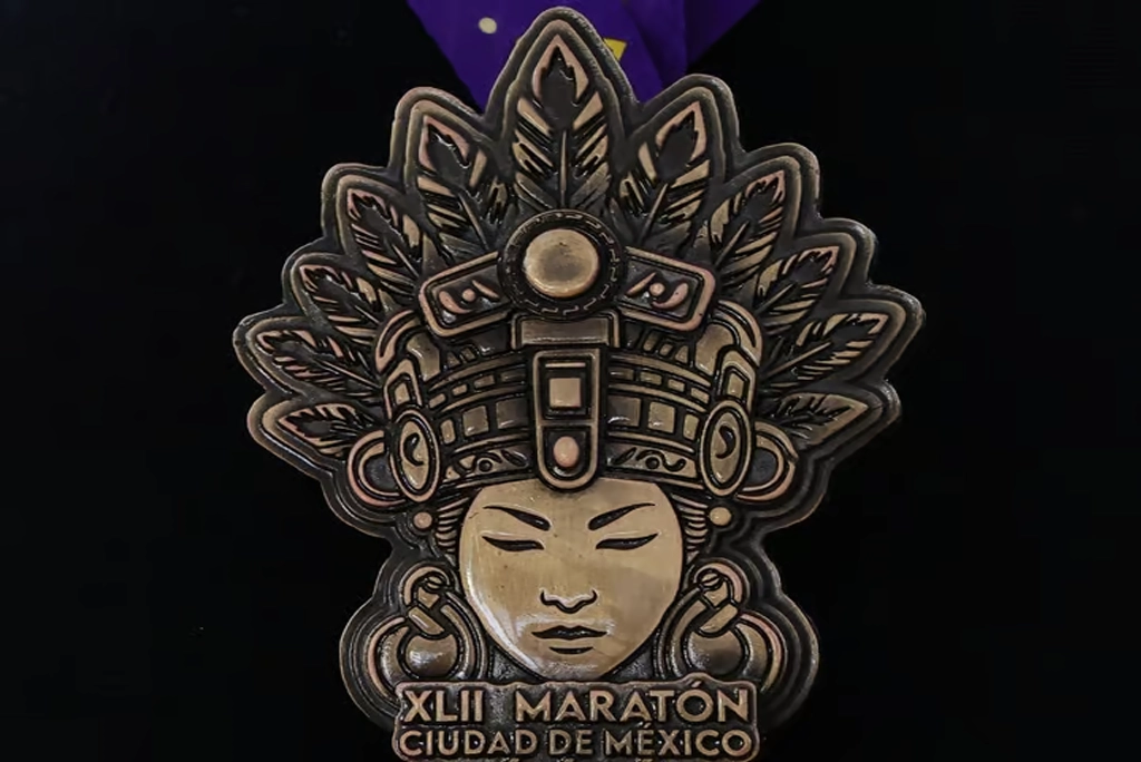 Medalla Maratón de la CDMX 2025 inspirada en Cihuacóatl, diosa mexica mujer serpiente, sobre fondo de textura prehispánica.