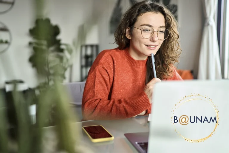Estudiante feliz usando computadora para estudiar bachillerato a distancia en la UNAM, con opción a pase reglamentado para licenciaturas en línea