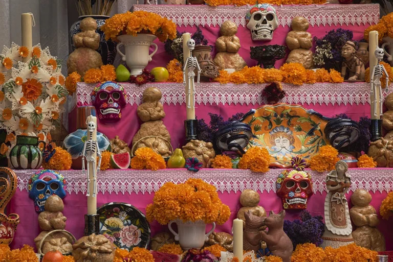 Guía visual sobre qué día poner la ofrenda de muertos: altar tradicional mexicano con cempasúchil, velas, calaveritas de azúcar y comida típica, mostrando las fechas clave para su colocación.