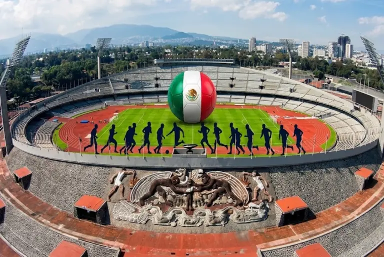 Genera una imagen moderna, con colores vibrantes y estilo editorial, donde se vea el Estadio Olímpico Universitario de la UNAM desde una vista aérea. Dentro, incluye un balón de futbol con los colores de México y una silueta de una selección internacional entrenando.