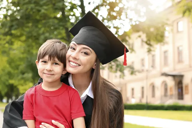 Mujer sonriente con su hijo, representando las becas para jefas de familia que apoyan la educación universitaria de madres en México.
