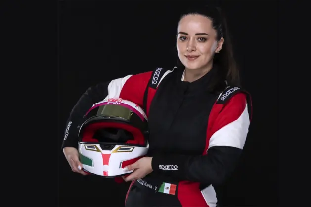 Piloto mexicana con traje de carreras y casco en mano, representando su participación en competencias internacionales de automovilismo.