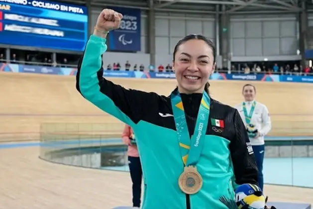 Yareli Acevedo, alumna de la UNAM, posa con su medalla de bronce y su casco con los colores del UNAM ciclismo sobre el velódromo de Hong Kong.