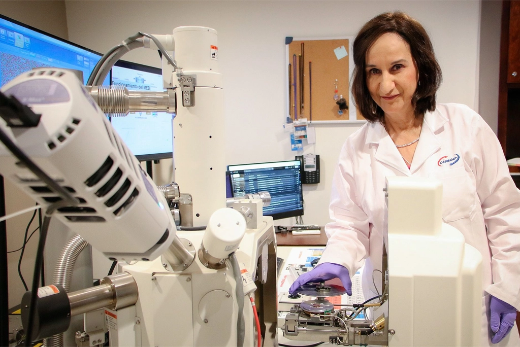 Retrato de la científica mexicana Leticia Myriam Torres Guerra, experta en ciencia de materiales, sosteniendo documentos que representan sus 9 patentes de científica mexicana, en un laboratorio de la UANL.