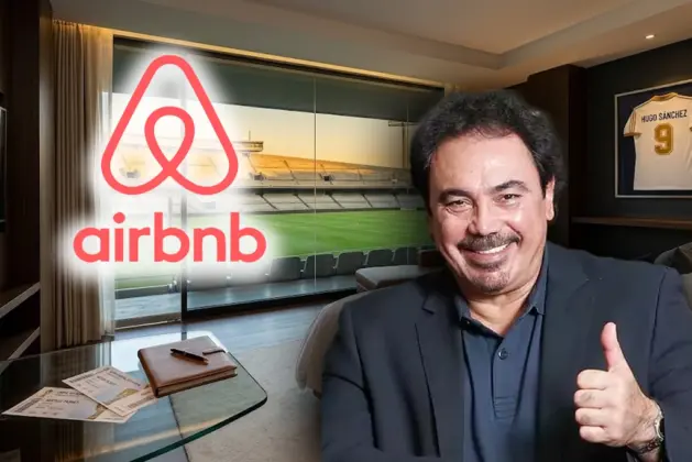 Suite privada con vista panorámica a la cancha del Estadio Azteca durante el atardecer, anunciando la experiencia de hospedaje Estadio Azteca Airbnb con detalles en la habitación y una playera de Hugo Sánchez colgada.