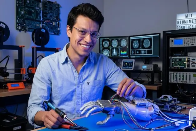 Joven ingeniero mexicano del MIT innova en prótesis en un laboratorio, iluminado por una luz LED azul sobre un ratón de experimentación con cables y equipos de neurociencia de fondo.