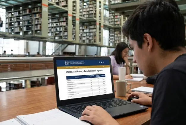 Joven aspirante consultando en su laptop la información oficial sobre los aciertos y lugares por carrera en la UNAM para planificar su ingreso.