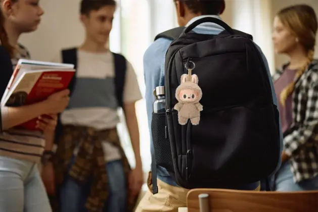 Joven estudiante de preparatoria con figura Labubu en su mochila, representando visualmente el concepto de por qué seguimos modas y tendencias colectivas.