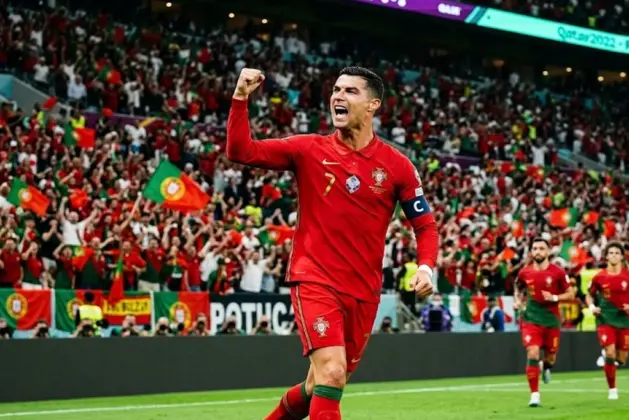 Fotografía realista de Cristiano Ronaldo celebrando uno de sus goles de Cristiano Ronaldo en mundiales con la camiseta de Portugal, levantando el puño en señal de victoria.
